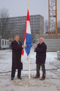 Wethouder John Levie (links) en Jan van den Bergh Jets hijsen de vlag